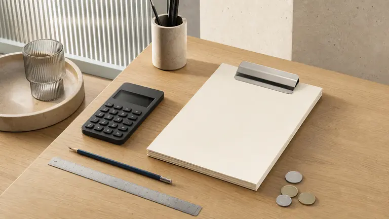 Calculatrice, devis vierge et outils de mesure sur une table de travail